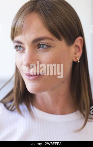 Donna caucasica con capelli marrone chiaro e occhi verdi che guardano lateralmente Foto Stock