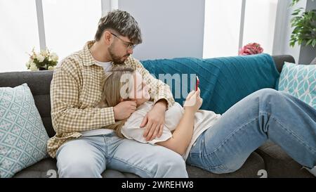 Una coppia amorevole gode di tempo di qualità su un comodo divano in un accogliente soggiorno, trasmettendo intimità e relax. Foto Stock