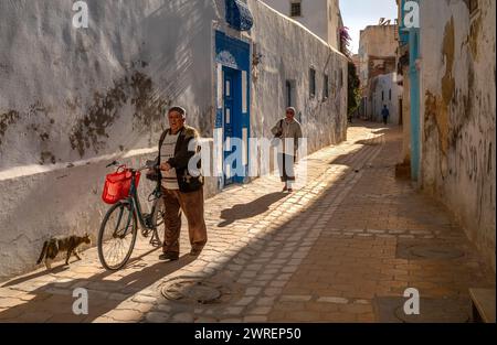 Un uomo anziano e la sua bicicletta all'interno dell'antica medina di Kairouan, Tunisia. La città è un sito patrimonio dell'umanità dell'UNESCO e il quarto sacro dell'Islam. Foto Stock