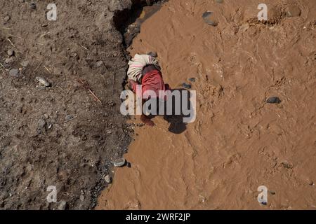 OMO MERIDIONALE - ETIOPIA - 19 NOVEMBRE 2011: Donna non identificata lava i vestiti nel fiume il 19 novembre 2011 a Omo Rift Valley, Etiopia. Foto Stock