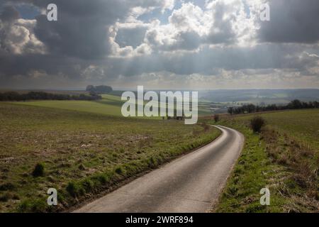 Corsia di campagna vuota a binario singolo che attraversa terreni agricoli aperti con un cielo spettacolare sopra, School Lane, East Garston, Berkshire, Inghilterra, REGNO UNITO Foto Stock