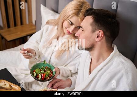 La bionda carina e suo marito fanno colazione in camera d'albergo Foto Stock