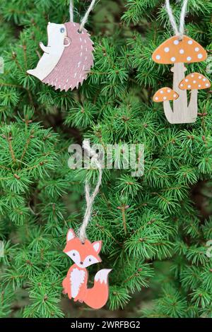 Giocattolo di volpe in legno appeso al ramo dell'albero di Natale. Decorazioni natalizie ecologiche. Foto Stock