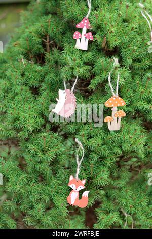 Decorazioni natalizie in legno su un abete verde. Foto ravvicinata di un ornamento natalizio realizzato a mano ecologico. Foto Stock