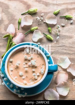 Un Teacup sul tavolo con fiori intorno Foto Stock