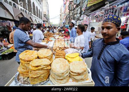 Il Ramadan nel Bangladesh i musulmani del Bangladesh comprano cibo per rompere il loro digiuno durante il primo giorno del mese di digiuno del Ramadan in un mercato alimentare tradizionale a Chalk bazar, a Dacca, Bangladesh, 12 marzo 2024. Il mese sacro dei musulmani del Ramadan è il nono mese del calendario islamico, e si ritiene che la rivelazione del primo versetto nel Corano sia stata durante le sue ultime 10 notti. E' anche il momento di socializzare, soprattutto la sera dopo aver rotto il digiuno, e di spostare tutte le attività alla fine della giornata nella maggior parte dei paesi. Dhaka Distretto di Dhaka Bangladesh Copyright: XHabiburxRahmanx Foto Stock