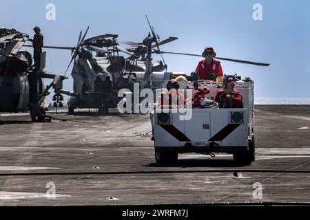 240206-N-PS818-1230 RED SEA (6 febbraio 2024) Aviation Boatswain's Mates (Handling), guida un camion antincendio in cabina di pilotaggio durante le operazioni di volo Foto Stock