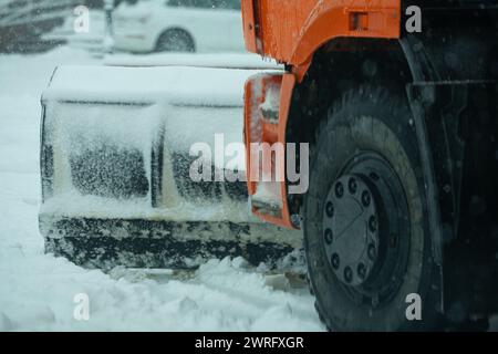 Manutenzione della conduttura salina. Spazzaneve su una strada innevata in azione. Condizioni climatiche avverse in inverno. Spandimento del veicolo.carrello spazzaneve. Alta qualità Foto Stock