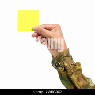 Scatto ritagliato di una mano dell'uomo irriconoscibile che tiene un notepaper giallo su uno sfondo bianco isolato Foto Stock
