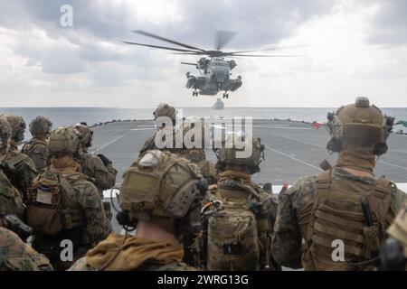US Marines con la forza di raid marittimo, la 31st Marine Expeditionary Unit, prepararsi a salire a bordo di un CH-53E Super Stallion durante una visita, imbarco e ricerca Foto Stock