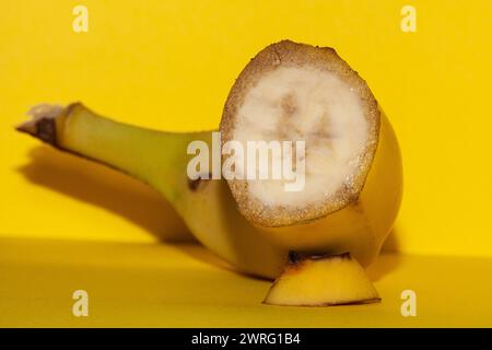 Le banane sono in via di estinzione, l'immagine macro di una banana è raffigurata su uno sfondo giallo come la buccia di questo frutto. Foto di alta qualità Foto Stock