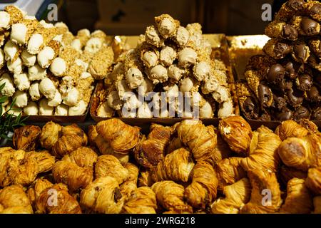 Una varieta' di delizie turche, caratterizzate da sapori e noci diversi, sono ordinatamente disposte su una banchina del mercato, pronte per l'acquisto da parte dei clienti. Foto Stock