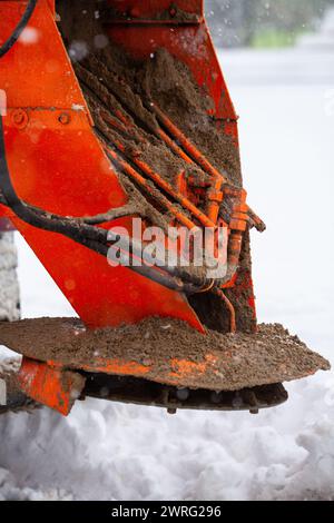 Salatura della manutenzione di autostrade. Spazzaneve su strada innevata in azione. Condizioni climatiche avverse in inverno. Spandimento del sale di sbrinamento del veicolo. Alta qualità p Foto Stock