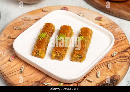 Kadayıf con pistacchi su fondo di legno. Prelibatezze della cucina turca. Dessert del Ramadan. nome locale birmania kadayif Foto Stock