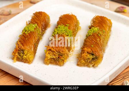 Kadayıf con pistacchi su fondo di legno. Prelibatezze della cucina turca. Dessert del Ramadan. nome locale birmania kadayif Foto Stock