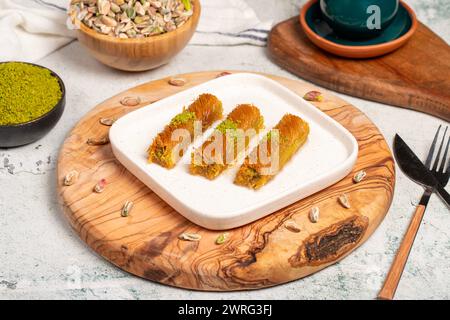 Kadayıf con pistacchi su fondo di legno. Prelibatezze della cucina turca. Dessert del Ramadan. nome locale birmania kadayif Foto Stock