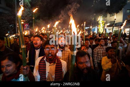 12 marzo 2024: I membri dell'All Assam Students' Union (AASU) prendono parte a un rally di fiaccole e gridano slogan per protestare contro l'attuazione del Citizenship Amendment Act (CAA), il 12 marzo 2024 a Guwahati, Assam, India. Il Citizenship Amendment Act (CAA), approvato dal Parlamento indiano nel 2019, infatti concede la cittadinanza accelerata a specifiche minoranze religiose provenienti da Afghanistan, Bangladesh e Pakistan che arrivarono in India il 31 dicembre 2014 o prima. Queste minoranze religiose includono indù, sikh, buddisti, giainisti, Parsi, e cristiani. (Immagine di credito: © David Ta Foto Stock