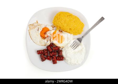 Polenta , uova fritte , salsicce e ricotta su un piatto bianco isolato su fondo bianco, piatte da vicino Foto Stock