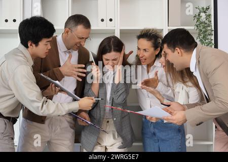 Giovane donna d'affari che soffre di colleghi rumorosi in ufficio Foto Stock