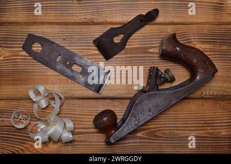 Piano per la lavorazione del legno smontato con raschiatura del legno su fondo di legno bruciato. Vista esplosa del piano di legno. 3 pezzi Foto Stock