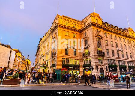 L'affollato Piccadilly Circus Crossing e l'edificio dei negozi sportivi Lillywhites, Londra, Inghilterra Foto Stock