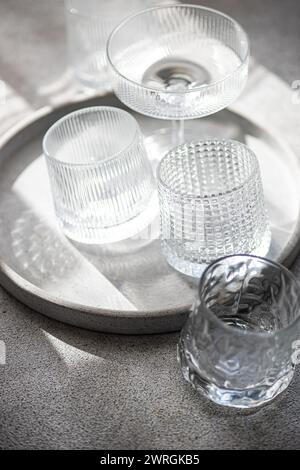 Primo piano di bicchieri da vino assortiti, coppe di champagne, bicchieri e bicchieri su un vassoio alla luce del sole Foto Stock