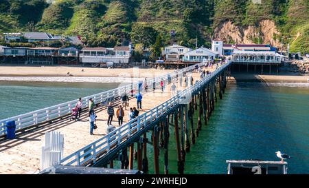 Malibu Pier, vista ad angolo alto. Molo di Malibu, California, in una soleggiata giornata estiva, con turisti che camminano sul lungomare lungo la costa. Foto Stock