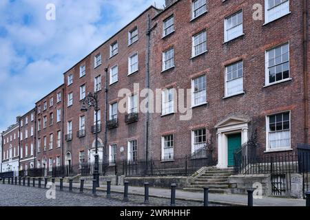 Fila di case cittadine in mattoni del XVIII secolo in una strada acciottolata a Dublino Foto Stock