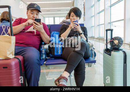 Merida Mexico, Aeroporto Internazionale Manuel Crescencio Rejon Merida, interno, area cancello dell'atrio del terminal, uomo asiatico uomini uomini, donna donna donna donna fe Foto Stock