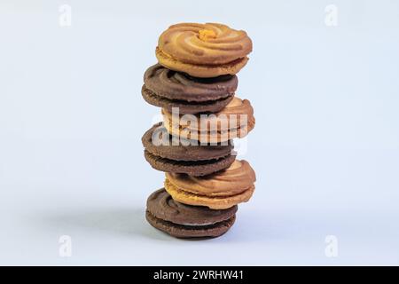 Succulenti primi piani di biscotti al cioccolato, disposti in modo ordinato in una pila perfetta su sfondo bianco Foto Stock