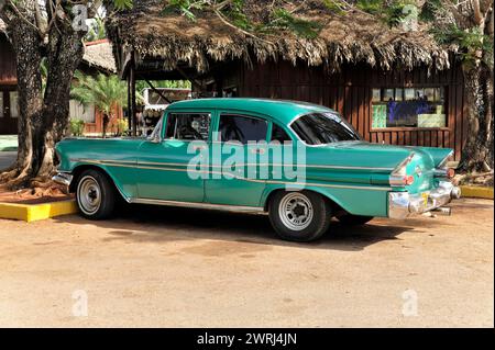 Auto d'epoca verde e bianca in perfette condizioni parcheggiata di fronte ad un edificio nella Cuba tropicale, nella penisola di Zapata, a Cuba, in America centrale Foto Stock