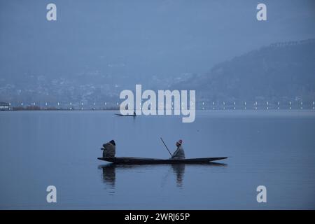 Srinagar, Jammu e Kashmir, India. 13 marzo 2024. I pescatori del Kashmir regnano le loro barche all'alba sul lago dal a Srinagar. (Credit Image: © Adil Abbas/ZUMA Press Wire) SOLO PER USO EDITORIALE! Non per USO commerciale! Foto Stock