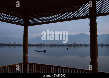 Srinagar, Jammu e Kashmir, India. 13 marzo 2024. I pescatori del Kashmir regnano le loro barche all'alba sul lago dal a Srinagar. (Credit Image: © Adil Abbas/ZUMA Press Wire) SOLO PER USO EDITORIALE! Non per USO commerciale! Foto Stock