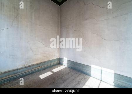 Camera vuota dalla vecchia casa abbandonata grunge con luce dalle finestre Foto Stock