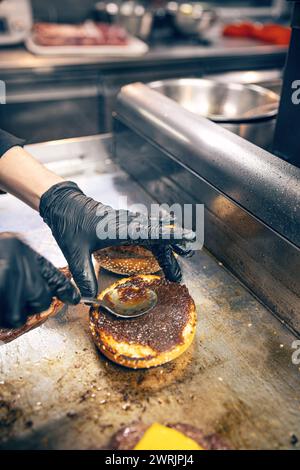 Processo di cottura dell'hamburger. Chef che prepara hamburger. Foto Stock