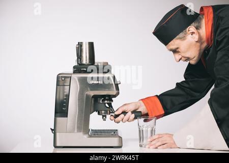 Il capo prepara diverse bevande a base di caffè espresso Foto Stock