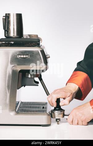 Premere il caffè macinato nell'impugnatura per estrarre il caffè nella macchina espresso Foto Stock