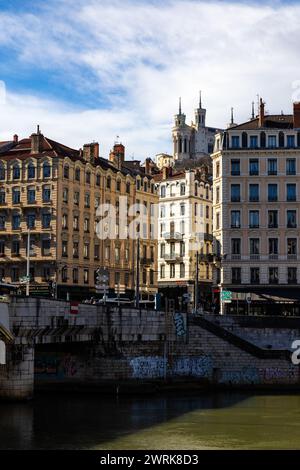 Basilique de Fourvière sur les hauteurs de Lyon émergeant entre les bâtiments depuis les quais de Saône Foto Stock