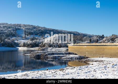 Barrage de Lavalette entourée d’une Forêt de sapins, dans les Gorges du Lignon, sous les premières neiges de l’hiver Foto Stock