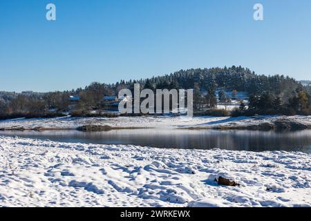 LAC de Lavalette entourée d’une Forêt de sapins, dans les Gorges du Lignon, sous les premières neiges de l’hiver Foto Stock
