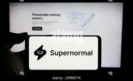 Persona che detiene un cellulare con il logo della società americana ai Supernormal Technologies Inc. Di fronte alla pagina Web aziendale. Mettere a fuoco il display del telefono. Foto Stock