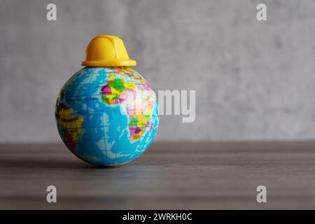 Elmetto in cima al mondo. Copia spazio per il testo. Giornata di lavoro, concetto di sicurezza prima di tutto. Foto Stock