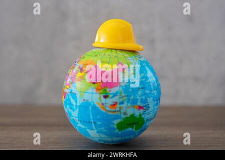 Elmetto in cima al mondo. Copia spazio per il testo. Giornata di lavoro, concetto di sicurezza prima di tutto. Foto Stock