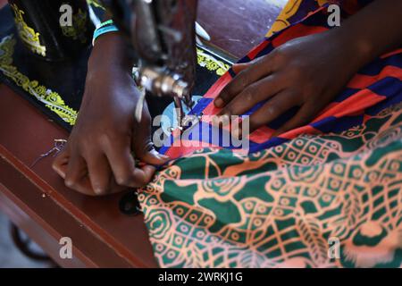 Donne e bambini immaginati di lavorare a mano per realizzare camicie all'Unione delle madri di Bo, Sierra Leone, Africa. Foto Stock