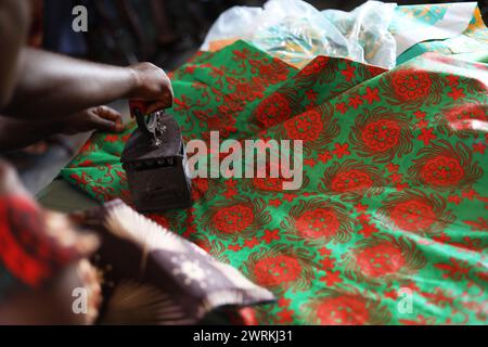 Donne e bambini immaginati di lavorare a mano per realizzare camicie all'Unione delle madri di Bo, Sierra Leone, Africa. Foto Stock