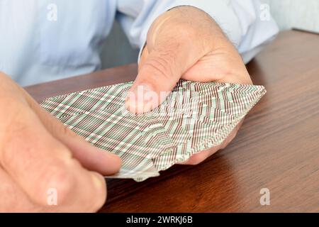 L'immagine mostra le mani del giocatore, in cui le carte. L'uomo pesca una carta dal mazzo. Foto Stock