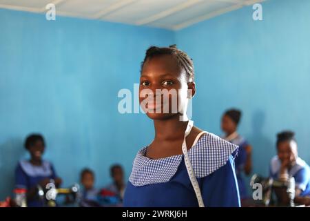 Donne e bambini immaginati di lavorare a mano per realizzare camicie all'Unione delle madri di Bo, Sierra Leone, Africa. Foto Stock