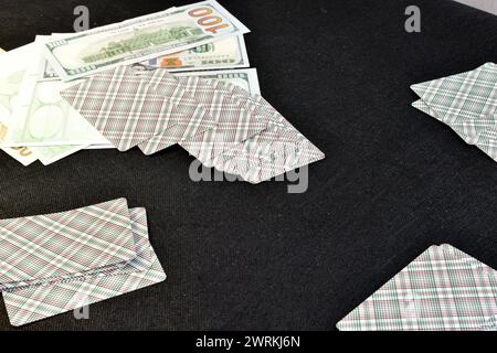 Sul tavolo ci sono carte, a faccia in giù, distribuite a quattro persone e soldi. Foto Stock