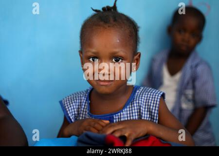 Donne e bambini immaginati di lavorare a mano per realizzare camicie all'Unione delle madri di Bo, Sierra Leone, Africa. Foto Stock