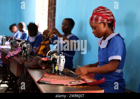 Donne e bambini immaginati di lavorare a mano per realizzare camicie all'Unione delle madri di Bo, Sierra Leone, Africa. Foto Stock